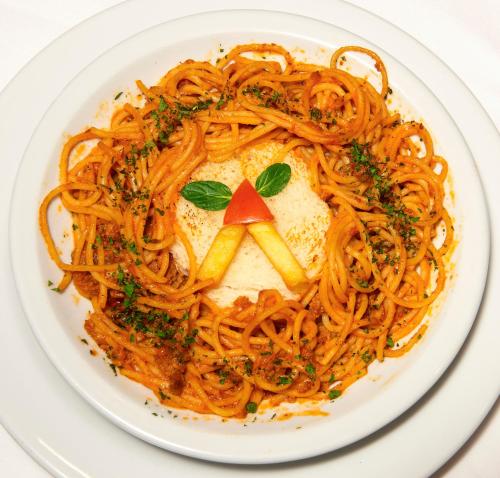 a plate of spaghetti with a tomato on top at B&B Garestin in Varaždin