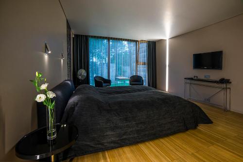 a bedroom with a bed with a table and a window at TonyResort in Trakai