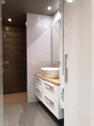 une salle de bain avec un lavabo blanc et une douche dans l'établissement Beautiful duplex in the center of Paris, à Paris