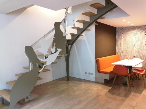 una escalera en una habitación con mesa y sillas en Beautiful duplex in the center of Paris, en París