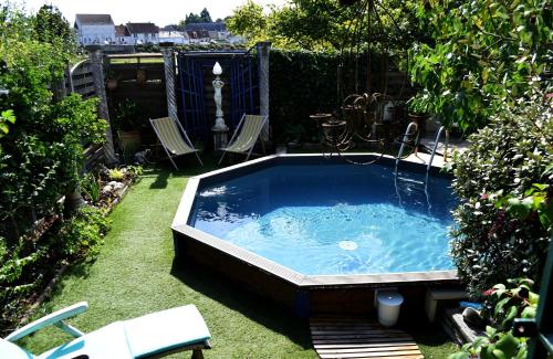 - un bain à remous dans une cour avec 2 chaises et une clôture dans l'établissement Gîte de charme Courjumelle, à Selles-sur-Cher