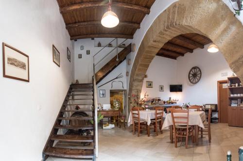 a dining room with a staircase and a table and chairs at Le Teste di Moro al Duomo in Agrigento