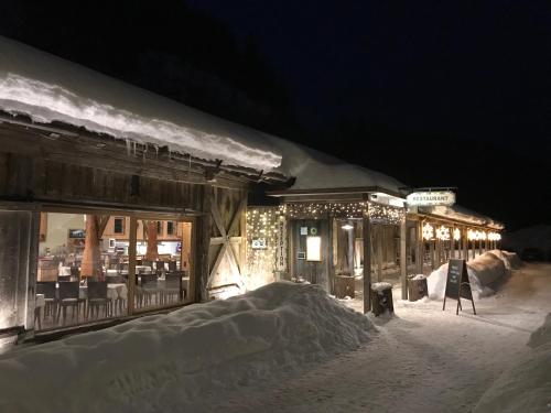 a building covered in snow at night with christmas lights at Gasthof Salzstadl in Reutte