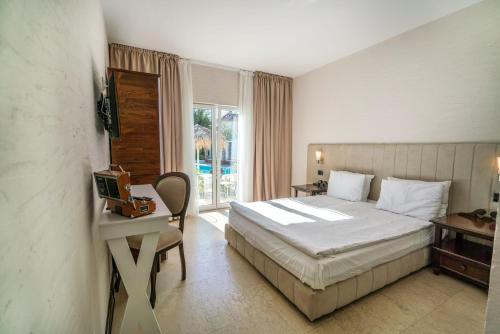une chambre avec un lit, un bureau et une fenêtre dans l'établissement Maris Vama Veche, à Vama Veche
