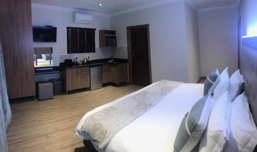 a bedroom with a large bed and a kitchen at TeBeacon Accommodation in East London