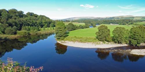 an aerial view of a river with trees and a field at Woodclose Park in Kirkby Lonsdale