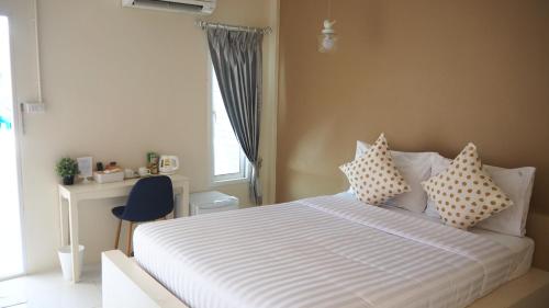 ein Schlafzimmer mit einem Bett mit Kissen und einem Fenster in der Unterkunft Sichon Modern House Hotel in Sichon