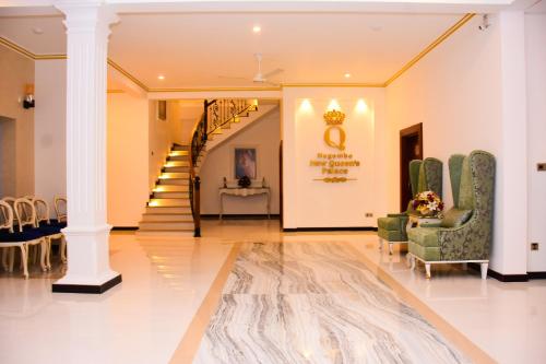 a lobby with a staircase and chairs and a table at Negombo New Queen's Palace in Negombo