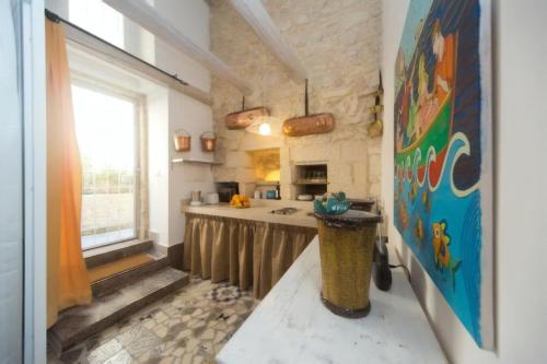 uma cozinha com um balcão e um lavatório num quarto em Luxury House Le Nuvole em Modica