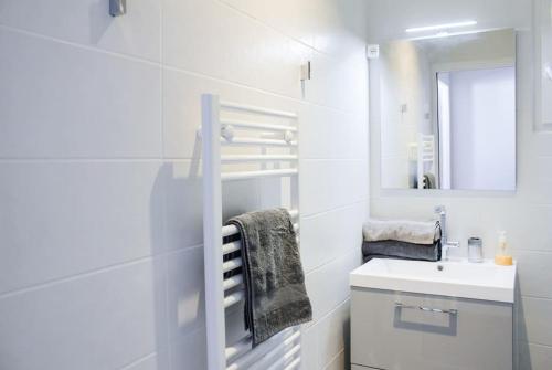 une salle de bain blanche avec un lavabo et un miroir dans l'établissement Les quais du Port, à Marseille