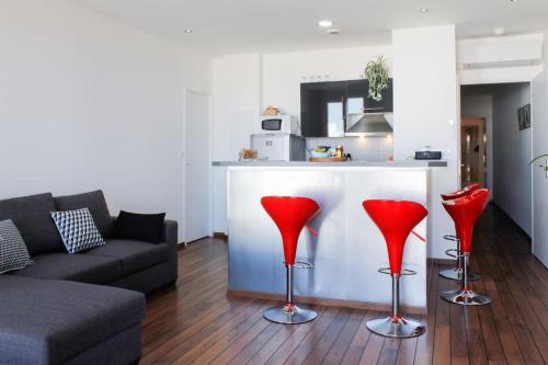 - un salon avec des chaises rouges en face d'un comptoir dans l'établissement Les quais du Port, à Marseille