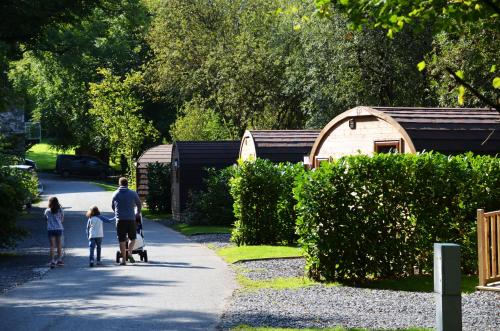 a man and two children walking down a sidewalk at Hill Of Oaks in Windermere