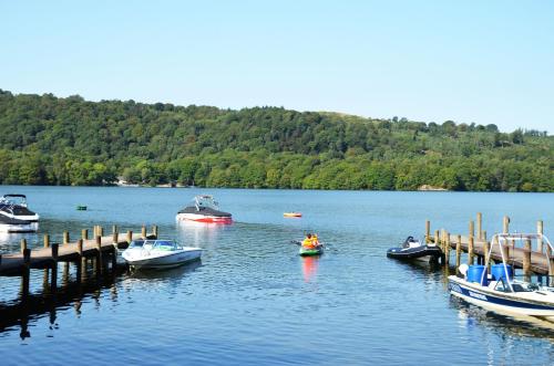 a group of boats parked at a dock on a lake at Hill Of Oaks in Windermere
