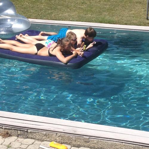 a group of people laying on a raft in a pool at Vermieterei in Oberwölbling
