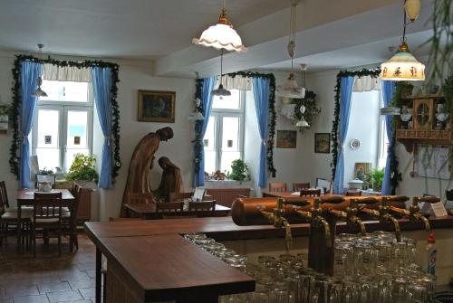 un restaurante con cortinas azules, mesas y sillas en Restaurace a penzion Ubrousku prostři se, en Nová Bystřice