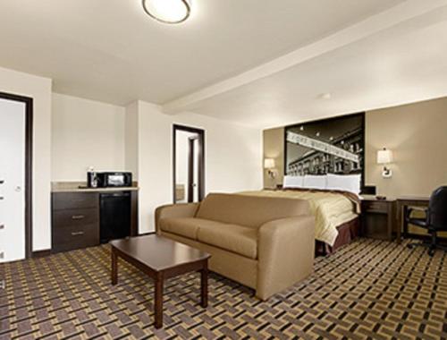 a hotel room with a couch and a bed at Super 8 by Wyndham Fort Worth TX in Fort Worth