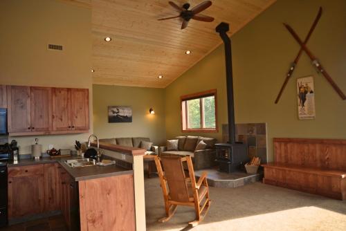 a kitchen and living room with a ceiling fan at Cedar House Restaurant & Chalets in Golden
