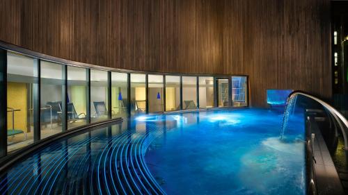a large swimming pool in a large building with a swimming pool at Sheraton Grand Hotel & Spa in Edinburgh