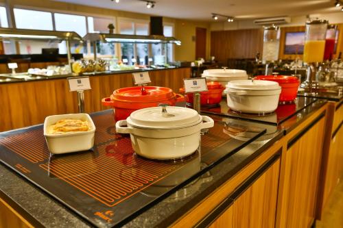 a buffet with several pots and pans on a counter at ARCUS Hotel By Atlântica in Aracaju