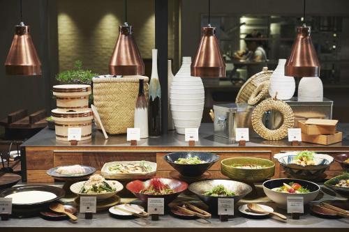 a buffet with bowls of food on a table at hotel MONday Premium TOYOSU in Tokyo