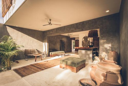 a living room with a couch a chair and a table at Panacea Condo Tulum in Tulum