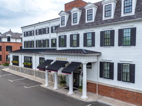 a white building with black awnings on a street at Delamar Southport in Southport