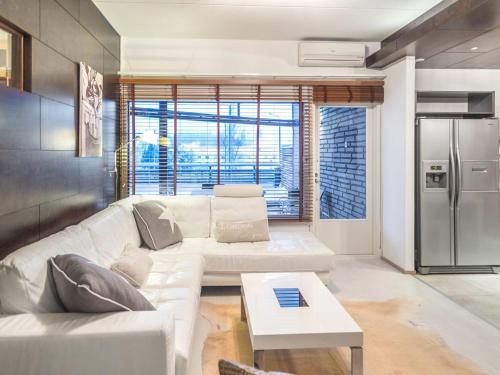 a living room with a white couch and a refrigerator at Holiday Home Tahko spa suites orange a 4- price inclu by Interhome in Tahkovuori