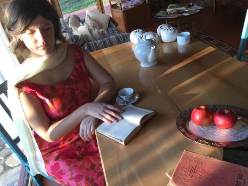 a young girl sitting at a table with a book at Azienda Agricola Il Querceto in Marsico Vetere