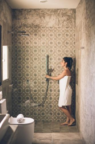 a woman standing in a shower in a bathroom at Panacea Condo Tulum in Tulum