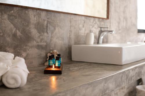 a bathroom with a sink and a counter with two bottles at Panacea Condo Tulum in Tulum
