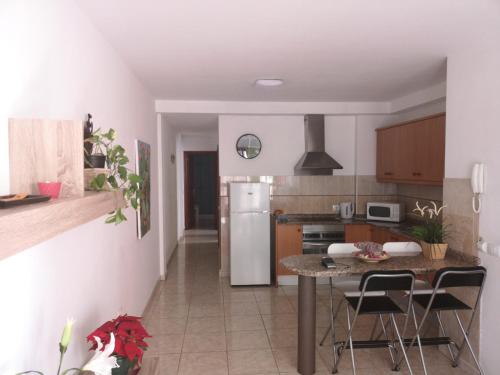 een keuken met een tafel en een koelkast bij Tajaste in Sardina