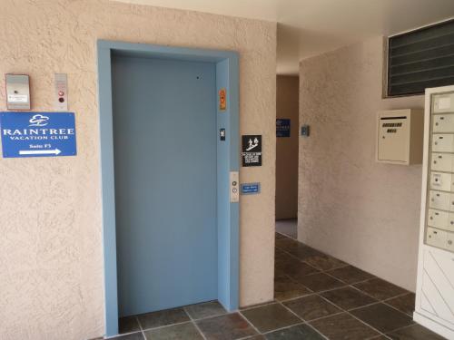 a blue door in a room with a sign on the wall at Kona Reef Resort by Latour Group in Kailua-Kona