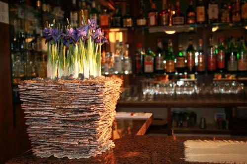 a vase filled with purple flowers in a bar at Albergo Nardini in Lentate sul Seveso
