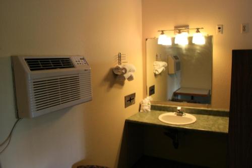 a bathroom with a sink and a mirror at Portland Value Inn & Suites in Portland