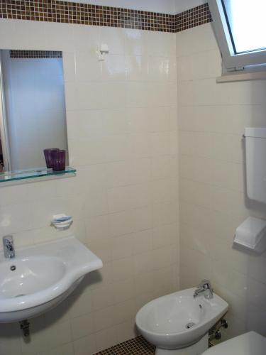 a white bathroom with a sink and a toilet at Hotel La Capinera in Bellaria-Igea Marina