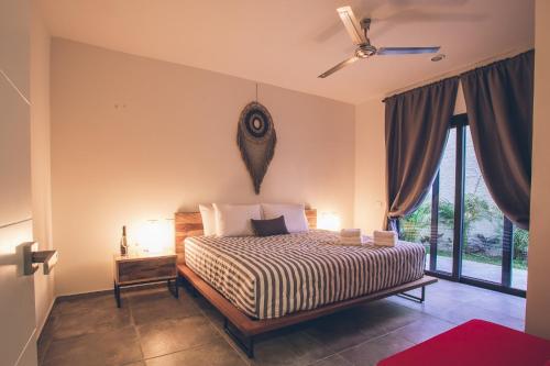 a bedroom with a bed and a ceiling fan at Panacea Condo Tulum in Tulum