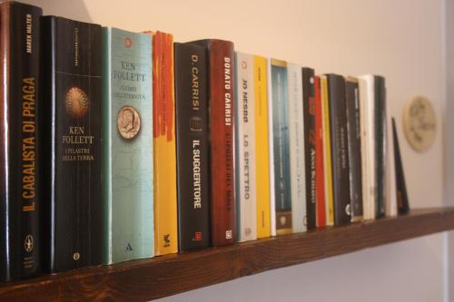 a row of books sitting on a shelf at Antica Fonte holiday home in Tavullia