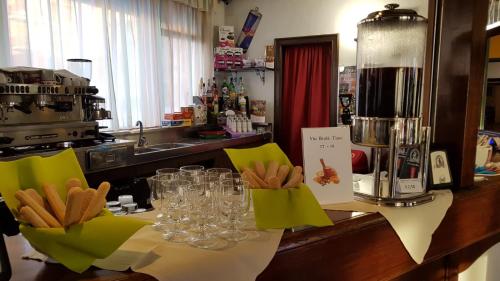 a kitchen counter with wine glasses on a table at Hotel Galassia in Prato Nevoso