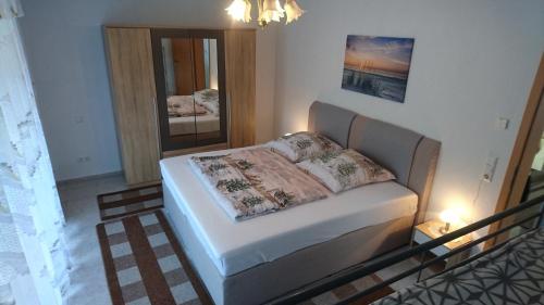 ein kleines Schlafzimmer mit einem Bett und einem Spiegel in der Unterkunft Ferienwohnung Andreas in Herbolzheim