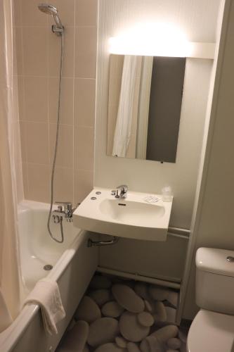 een badkamer met een wastafel, een toilet en een spiegel bij Hotel Inn Design Moutiers in Moutiers