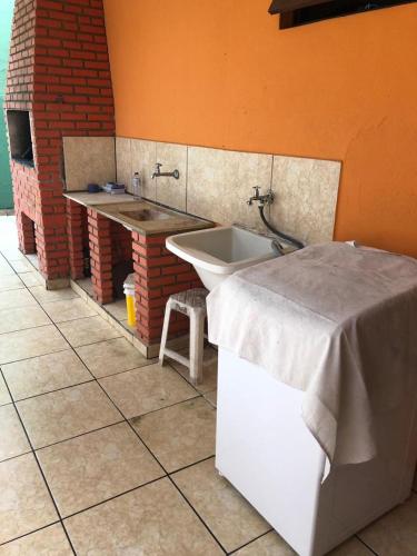 łazienka z umywalką, wanną i stołem w obiekcie casa em Martins de Sá w mieście Caraguatatuba