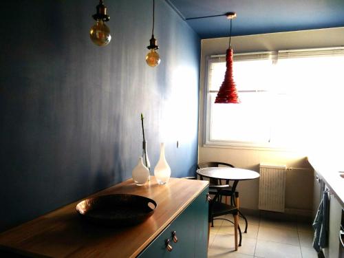 コロンブにあるColombes Bleuのキッチン(花瓶付きの木製カウンター、テーブル付)