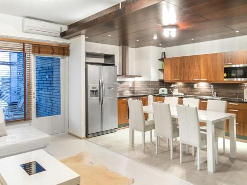 una cucina con tavolo, sedie e frigorifero di Holiday Home Tahko spa suites orange a 4- price inclu by Interhome a Tahkovuori