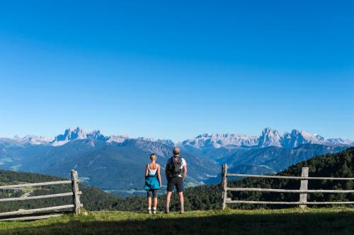 a man and a woman standing on top of a mountain at Boutique Pension Erlacher - Adults Only in Villandro
