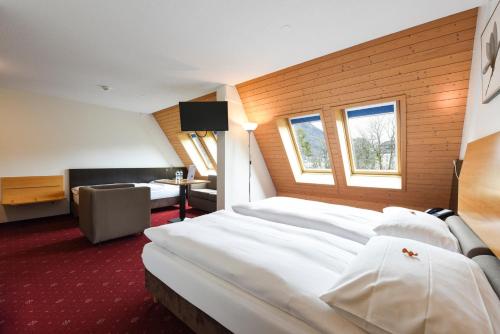 a hotel room with two beds and a chair at City Hotel in Brunnen