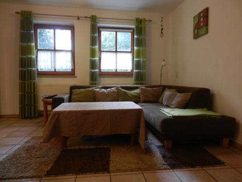 a living room with a couch and a coffee table at Ferienhof Löw in Salzweg