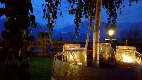 a table with glasses on top of a barrel with a candle at Boutique Pension Erlacher - Adults Only in Villandro