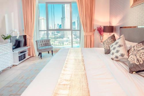 a hotel room with a large bed with a large window at Burj Grand Apartment - Four Bedrooms in Dubai