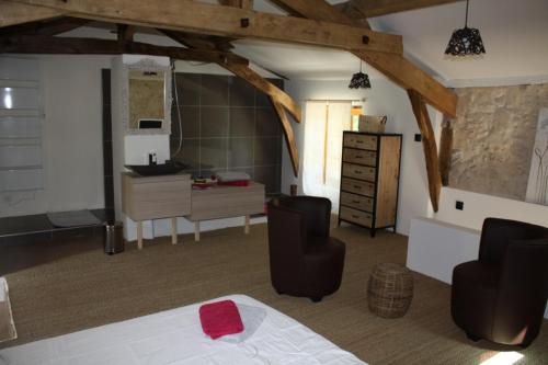 une chambre avec un lit et un bureau et une cuisine dans l'établissement Gîtes Grand Pré ! et la Roulotte de Roquecor, à Roquecor