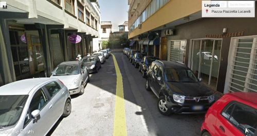 a row of cars parked on a street next to buildings at Badia in Aversa